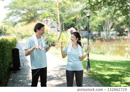 Wellness and Senior Interaction. A couple playfully engaging during their outdoor exercise routine. 132662729