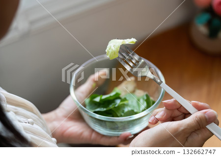 Healthy Eating and Wellness. A person enjoying a fresh salad, emphasizing the importance of nutritious food for overall health. Healthy Eating and Wellness. A person enjoying a fresh salad, emphasizing the importance of nutritious food for overall health. 132662747