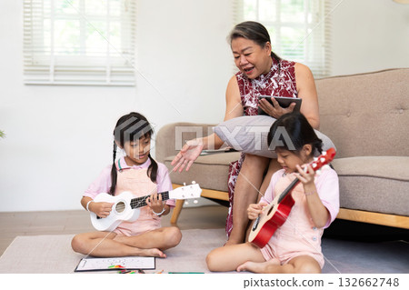 Back to School and Music Learning. A grandmother teaches her granddaughters how to play instruments. Back to School and Music Learning. A grandmother teaches her granddaughters how to play instruments. 132662748
