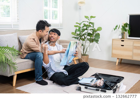 Travel Planning and LGBT Couple. Two men excitedly planning their next vacation together at home. 132662777