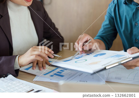 Collaboration and Strategy Discussion. Two professionals analyzing data together in an office environment. 132662801