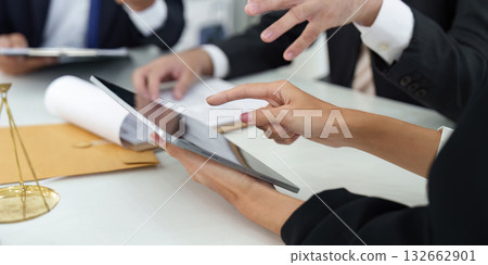 Digital Tools and Legal Consultation. A lawyer utilizing a tablet for client discussions and document reviews in a modern legal setting. 132662901