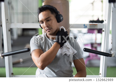 Post-Workout Recovery. Man stretching shoulder after exercise in gym. Post-Workout Recovery. Man stretching shoulder after exercise in gym. 132662989