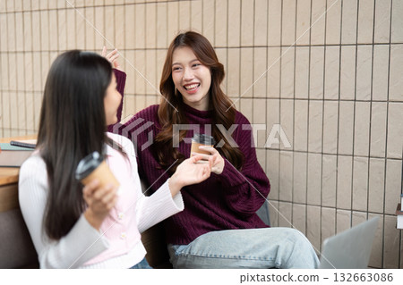 Friendship and Coffee Break. Two students enjoying a coffee break while catching up Friendship and Coffee Break. Two students enjoying a coffee break while catching up 132663086