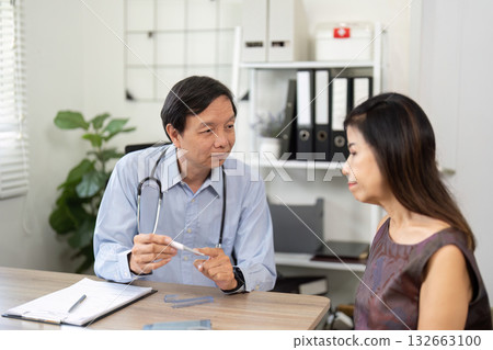 Doctor-Patient Discussion and Medical Guidance. A physician explaining treatment options to a patient in a clinical setting. 132663100
