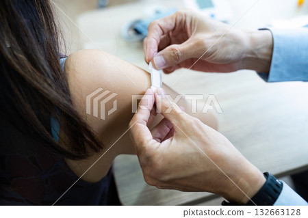 Medical professional administering a vaccine to patient in clinic Medical professional administering a vaccine to patient in clinic 132663128