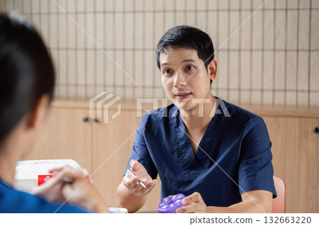 Team Doctor and Meeting. A healthcare professional explains treatment options during a team meeting. Team Doctor and Meeting. A healthcare professional explains treatment options during a team meeting. 132663220