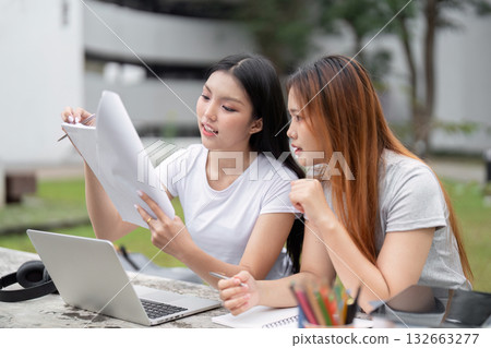 Focus and Study Techniques. Two students collaborating on their studies, reviewing documents in an inviting study space. 132663277