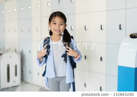 Back to School: Young Girl Posing with Backpack at School Lockers Back to School: Young Girl Posing with Backpack at School Lockers 132663280