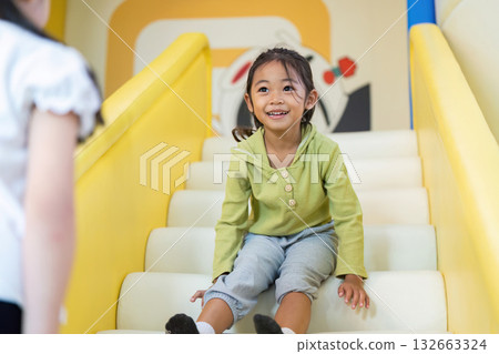 Child on Slide Steps. Happy girl preparing to slide down at colorful playground. Child on Slide Steps. Happy girl preparing to slide down at colorful playground. 132663324