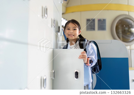 Back to School. Girl Smiling While Opening Locker in School 132663326
