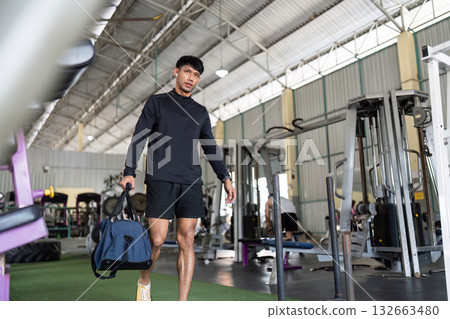 Man arriving at gym with workout bag for fitness session Man arriving at gym with workout bag for fitness session 132663480