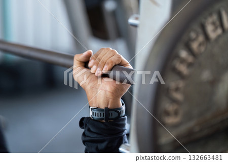 Strength Training. Close-up of a hand gripping a barbell during a weightlifting session. Strength Training. Close-up of a hand gripping a barbell during a weightlifting session. 132663481