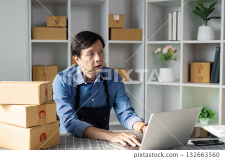 E-commerce professional focused on online tasks at a laptop in a workspace. E-commerce professional focused on online tasks at a laptop in a workspace. 132663560