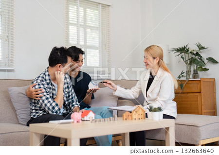 Couple receiving real estate investment advice from a consultant in a modern living room Couple receiving real estate investment advice from a consultant in a modern living room 132663640
