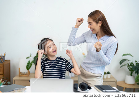Back to School and Celebrating Achievements. A girl and her mother celebrate success in online learning. Back to School and Celebrating Achievements. A girl and her mother celebrate success in online learning. 132663711