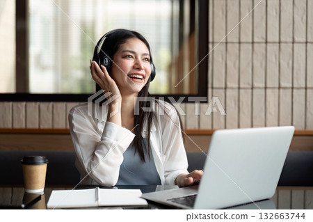 Engagement and Communication. A young woman enjoying an online session with headphones. 132663744