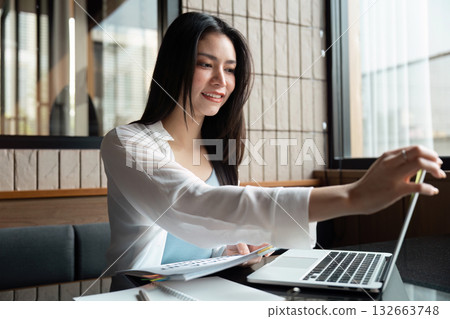 Productivity and Digital Engagement. A woman engaged in a productive laptop session. 132663748