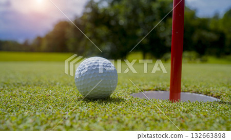 Golf ball is on a green lawn in a beautiful golf course with morning sunshine. 132663898