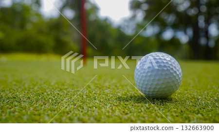 Golf ball is on a green lawn in a beautiful golf course with morning sunshine. Golf ball is on a green lawn in a beautiful golf course with morning sunshine. 132663900