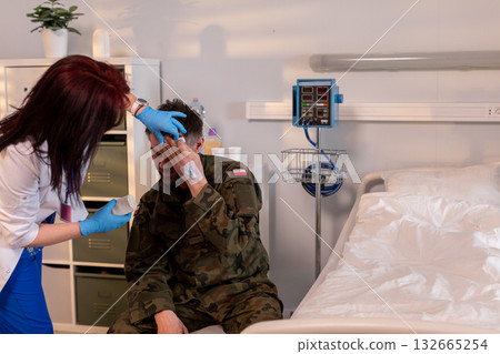 A dedicated military medic is providing essential assistance to a soldier in the recovery room 132665254