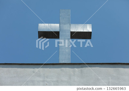 A Silver Cross Set Against a Beautiful and Clear Blue Sky Evokes Deep Spiritual Feelings 132665963