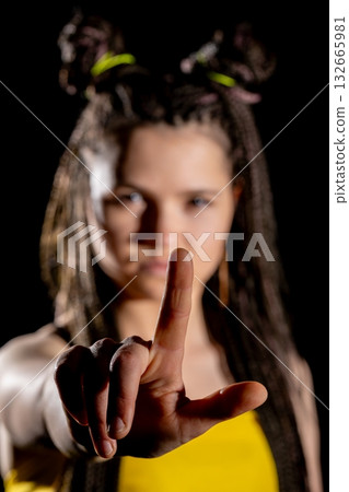 A Stylish Young Woman with a Peace Sign Gesture, Posing Confidently in a Vibrant Urban Setting 132665981