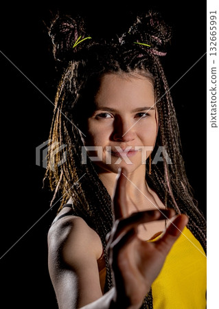 A youthful woman wearing yellow with a playful expression that exudes joy and liveliness 132665991