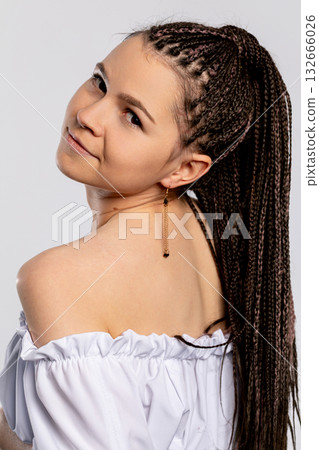 A Stylish Young Woman with Beautifully Braided Hair Posing in an OffShoulder Top A Stylish Young Woman with Beautifully Braided Hair Posing in an OffShoulder Top 132666026