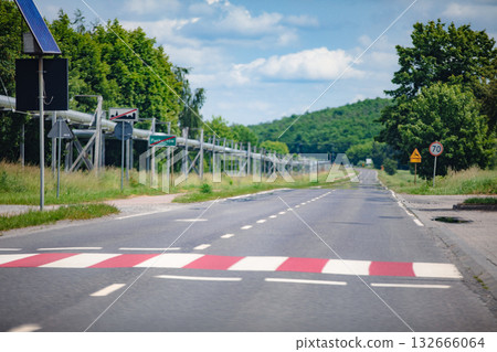 A peaceful rural road with a speed bump and traffic signs, highlighting countryside tranquility A peaceful rural road with a speed bump and traffic signs, highlighting countryside tranquility 132666064