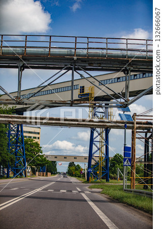An industrial roadway that runs beneath steel structures, offering urban connectivity and access An industrial roadway that runs beneath steel structures, offering urban connectivity and access 132666067