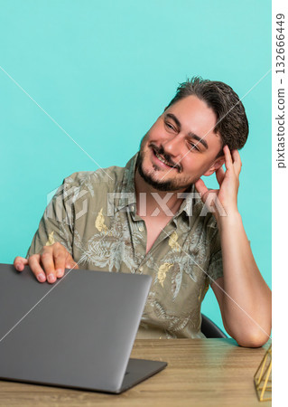 Man sitting at table closing laptop smiling with relief, happy after finishing work or online task 132666449