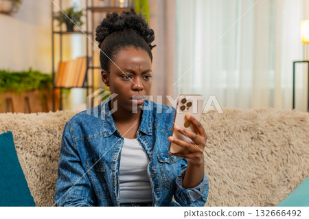 African American young woman reacts sadly after losing mobile game and reading bad test results 132666492