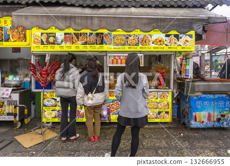 Lijiang, China - April 12, 2024 : Local food stall shop at flea market in Lijiang Old Town, China on April 12, 2024. Lijiang, China - April 12, 2024 : Local food stall shop at flea market in Lijiang Old Town, China on April 12, 2024. 132666955