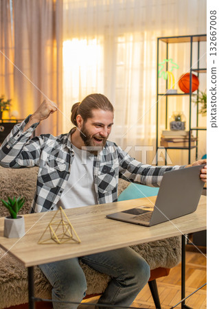 Young man man opens laptop at home wow great winning result in an online course celebrates victory Young man man opens laptop at home wow great winning result in an online course celebrates victory 132667008