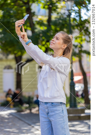 Young female tourist trying to catch a communication signal and Internet on cellphone in city street Young female tourist trying to catch a communication signal and Internet on cellphone in city street 132667014