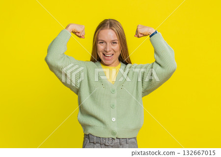 Happy woman looking confident showing biceps feeling power strength to fight for rights success win 132667015