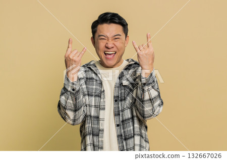 Happy Asian man showing rock n roll gesture by hands cool sign crazy expression dancing victory win Happy Asian man showing rock n roll gesture by hands cool sign crazy expression dancing victory win 132667026