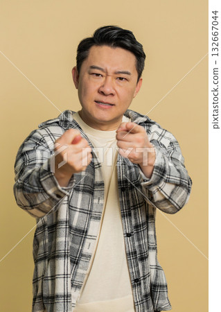 Angry aggressive Asian man showing fig negative gesture, refusal fig sign, rapacious, avaricious 132667044