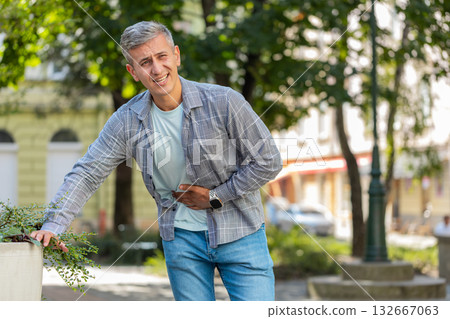 Caucasian man traveler feeling sudden strong abdominal stomach ache gastritis problem on city street Caucasian man traveler feeling sudden strong abdominal stomach ache gastritis problem on city street 132667063