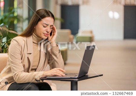 Tired businesswoman freelancer use laptop suffering from headache problem tension migraine stress Tired businesswoman freelancer use laptop suffering from headache problem tension migraine stress 132667469