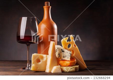 Assorted cheeses paired with glass of wine on a rustic table Assorted cheeses paired with glass of wine on a rustic table 132668294