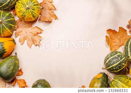 Autumn still life with pumpkins and leaves on beige background 132668331
