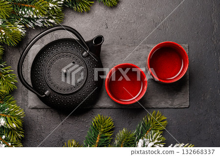 Christmas tea setting with teapot, cups, and fir tree branches 132668337