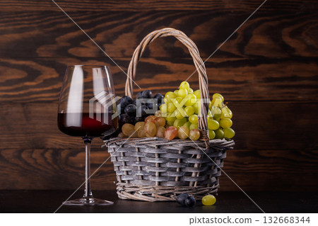 Red wine glass and basket of fresh grapes Red wine glass and basket of fresh grapes 132668344