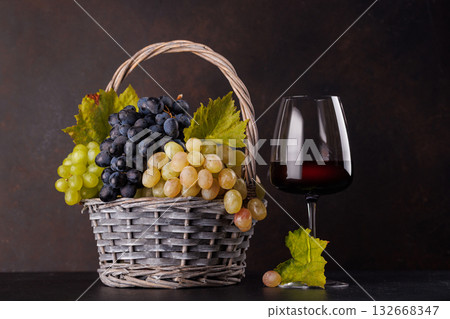Red wine bottle with a glass and basket of fresh grapes Red wine bottle with a glass and basket of fresh grapes 132668347