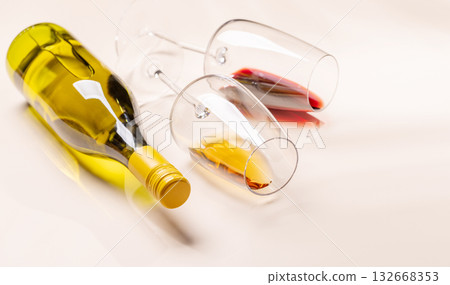 Wine glasses with red and white wine lying on beige background Wine glasses with red and white wine lying on beige background 132668353