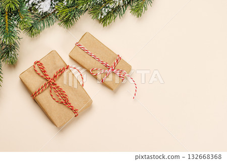 Christmas card with fir branches and gift boxes on beige surface, 132668368