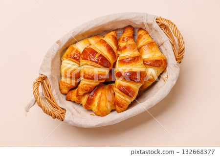 Freshly baked croissants in wicker basket on light background Freshly baked croissants in wicker basket on light background 132668377