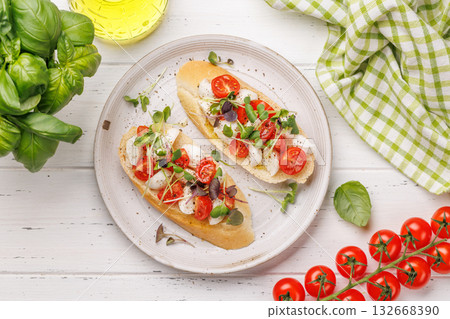 Tasty antipasto toasts featuring classic caprese with mozzarella and tomatoes, and savory prosciutto with herbs 132668390